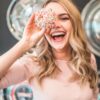 shallow focus photography of woman holding doughnut